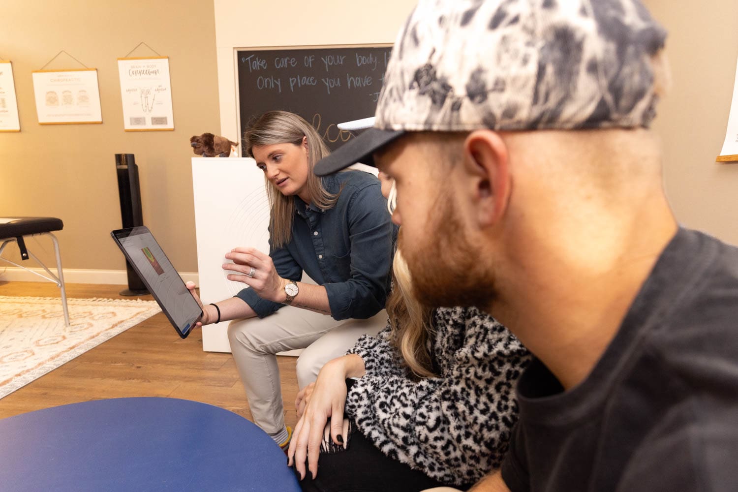 Taylor Houck explaining the results of an INSiGHT neurological scan to a patient, helping them to see where the root of their health issues may be