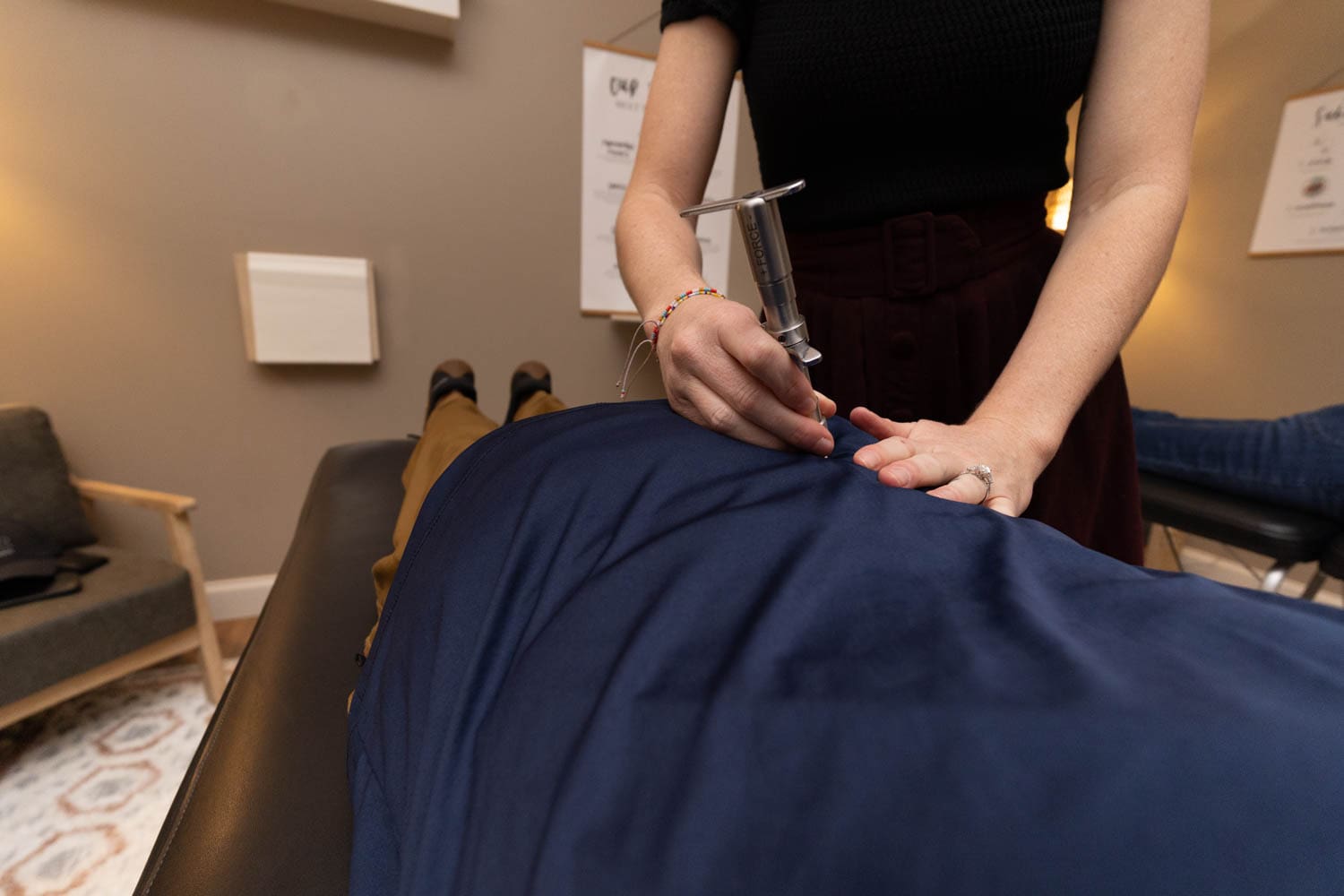 Dr. Tara performing a TRT Chiropractic adjustment on a patient to relieve back pain