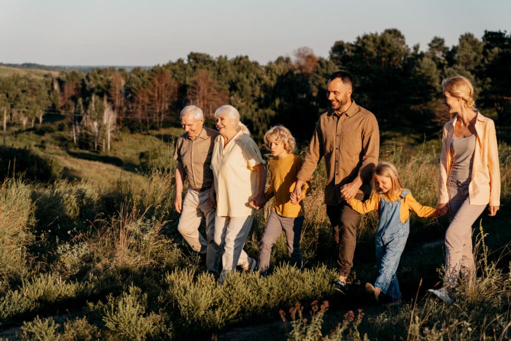 Multigenerational family walking in a field at golden hour